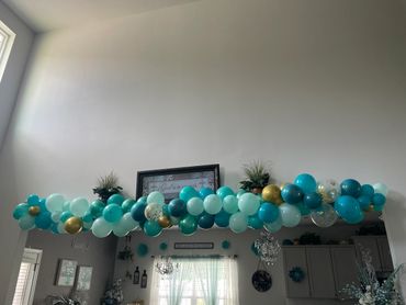 Blue and gold balloon garland decorating an indoor archway.
