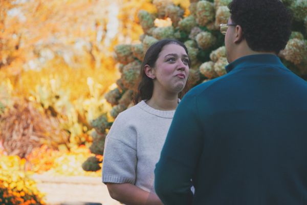 Woman looking emotional while talking to a man outdoors.