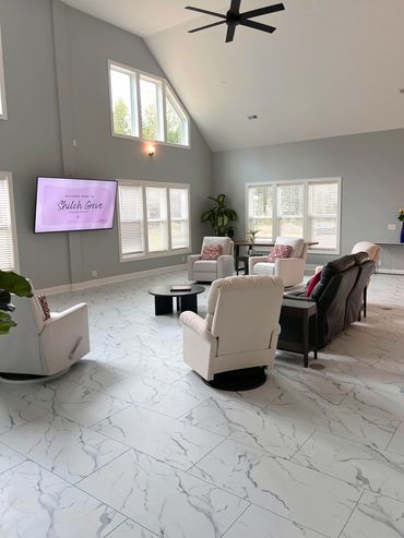 Bright and modern senior living lounge with comfortable seating and a wall-mounted TV.