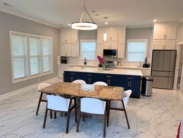 Modern kitchen with blue island and marble dining table.