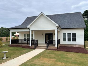 Modern white house with a black roof and front porch.