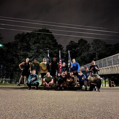 Group of people posing outdoors at night with flags.