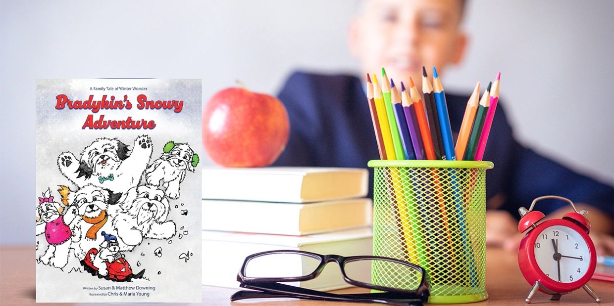 A child's study desk with colorful pencils, books, an apple, glasses, and a red clock.