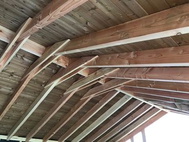 Detail van de houten dakconstructie met gebogen kepers en binnenafwerking in planchetten.