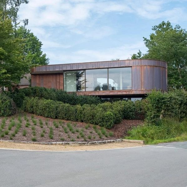 Zijaanzicht van een nieuwbouwwoning met afgewerkt groendak en strakke lijnen