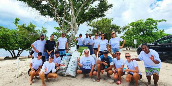 group picture of 20 volunteers and trash bags full of plastic waste during our costal clean up event