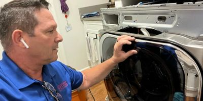 Pristine Appliance Technician repairing a washing machine at a residential home in Port Saint Lucie.