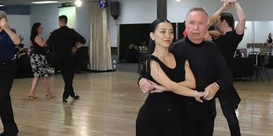 Student Ken partner dancing East Coast Swing with his instructor Bonnie. 
