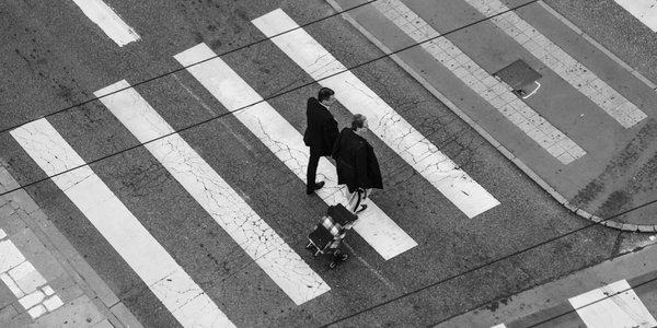 Two men walking on crosswalk in black and white