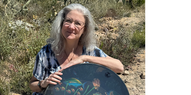 Dalena Watson in Arizona desert with ocean drum. Custom workshops, training for mental health