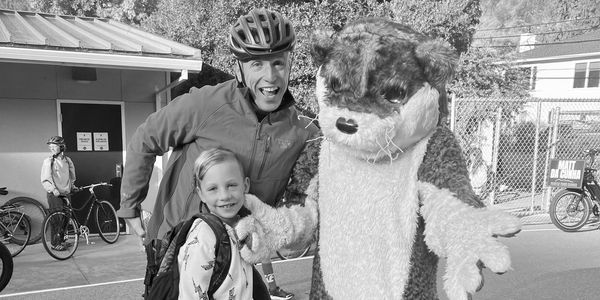 A man, a child, and a mascot enjoying a day outdoors.