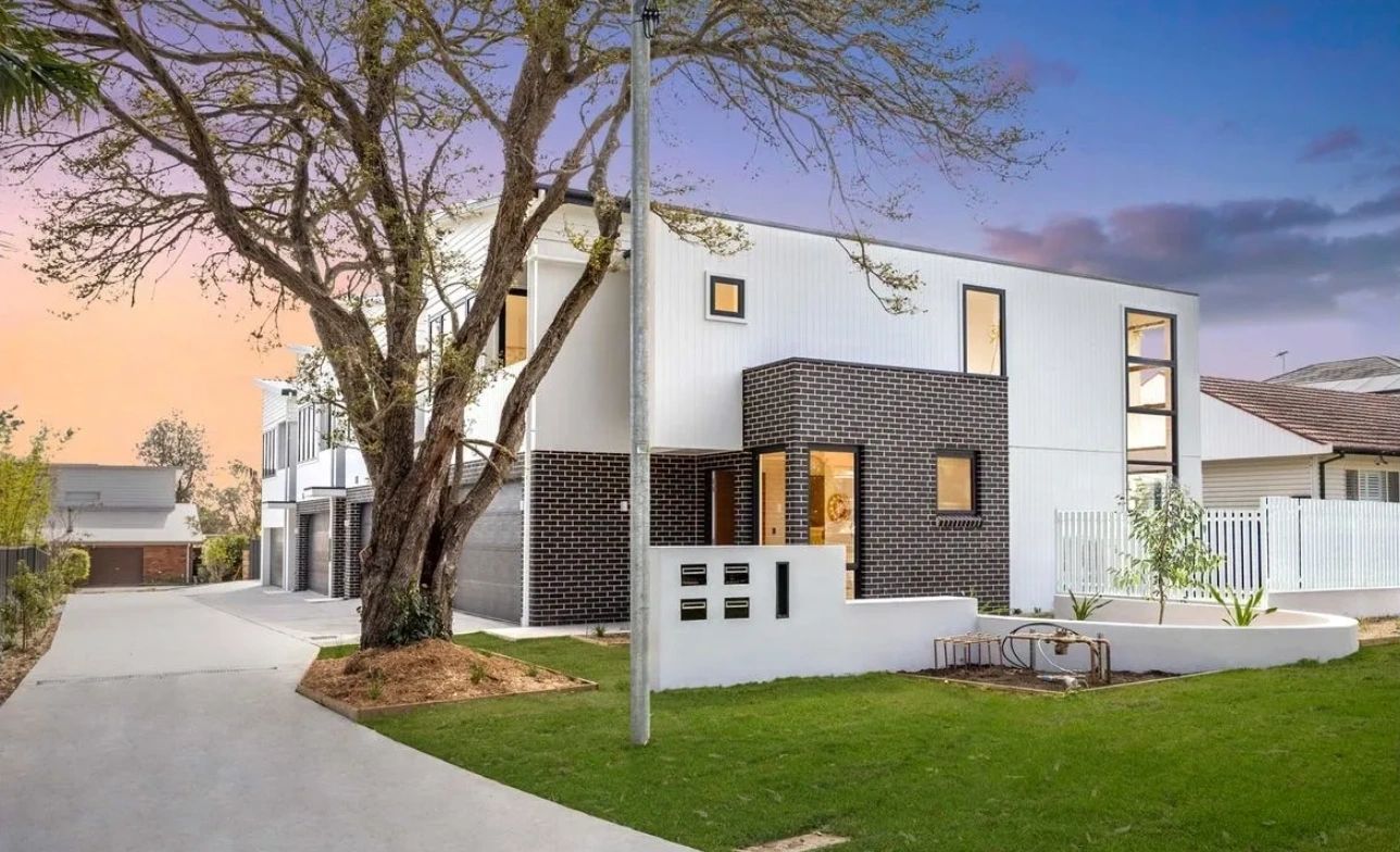 Modern two-story house with brick and white panel exterior.