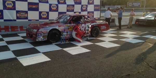 Race car and driver at victory lane.