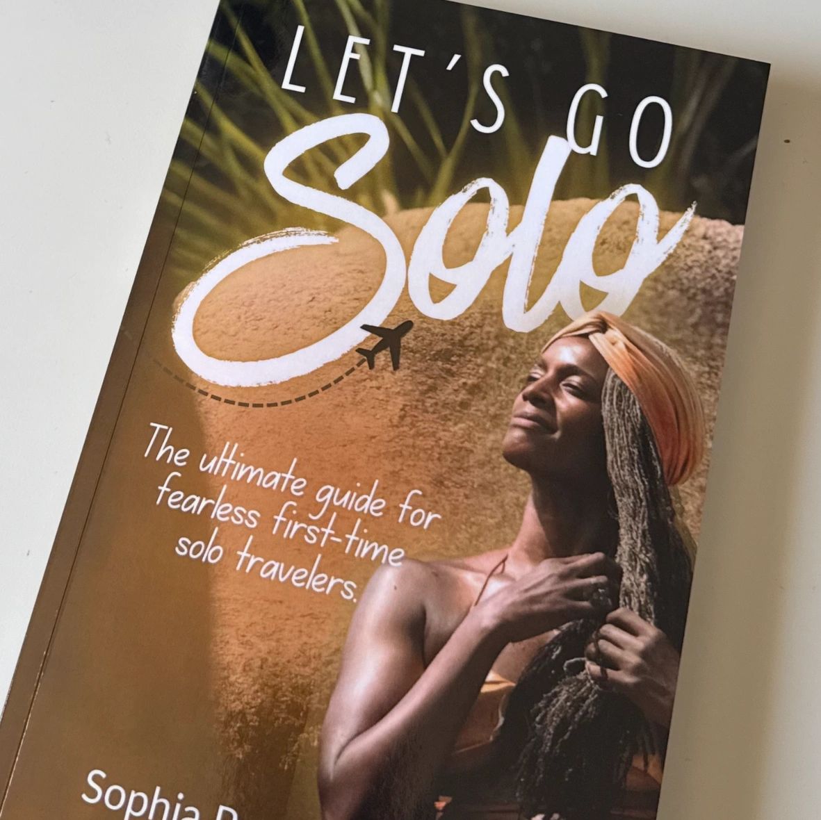 Book titled 'Let's Go Solo' for fearless first-time solo travelers by Sophia Pryce.