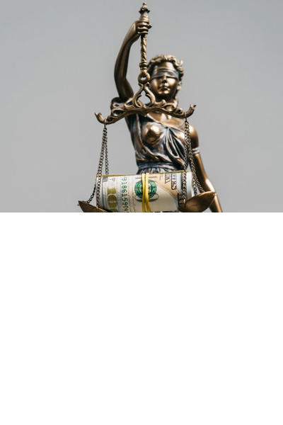 Statue of Lady Justice holding scales with a roll of money.