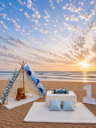 Beach setup for a first birthday celebration at sunset.