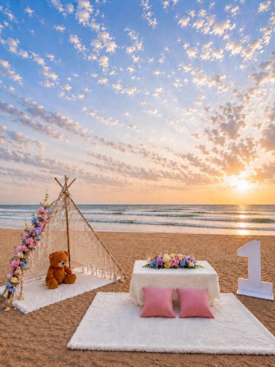 Beach setup with teepee, teddy bear, and large number one.