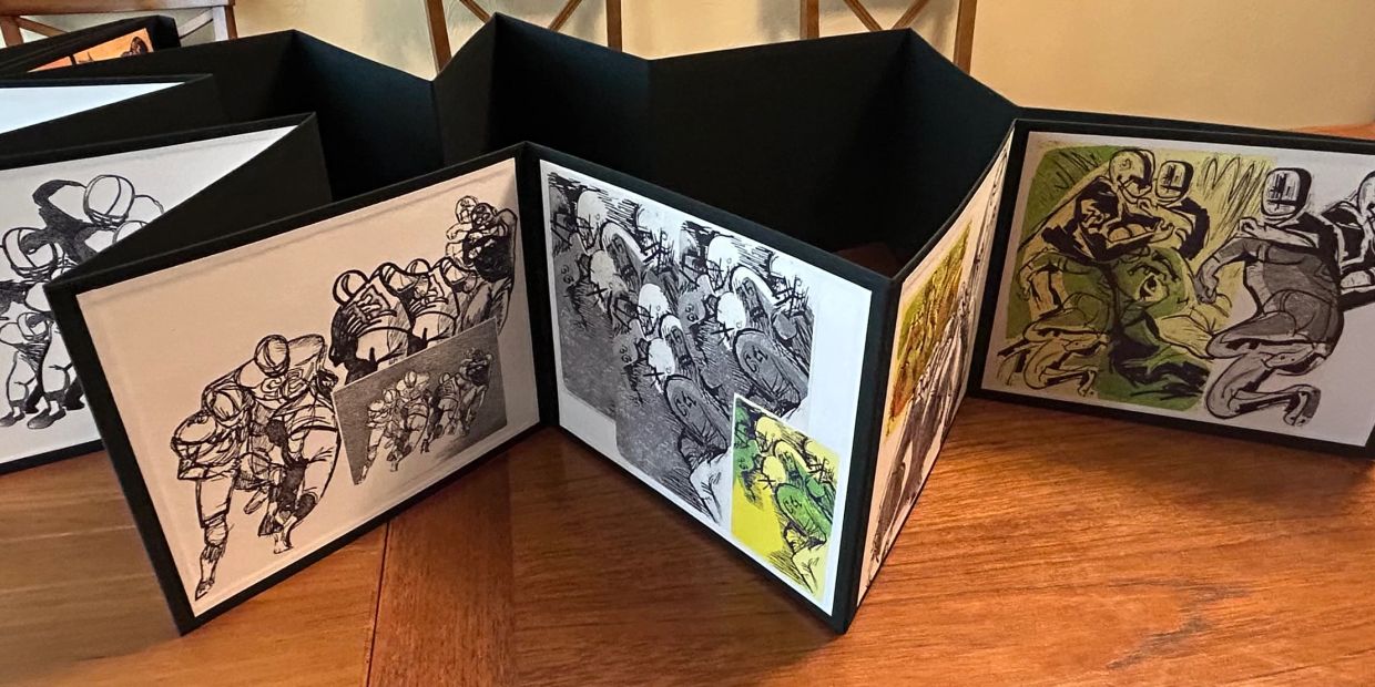 Accordion-style football sketch art displayed on a table.