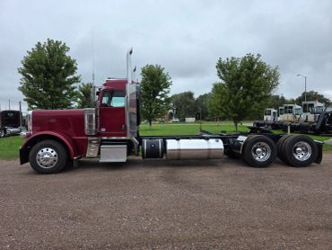Side view of a maroon semi truck without a trailer.