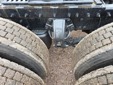 Close-up of truck tires and suspension system.