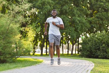 Guy jogging through park