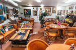 The chairs' backs and seats are hand-stitched, and the table includes intricate wood carvings,