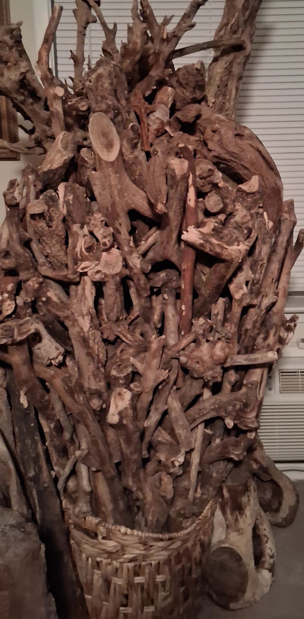 Basket filled with a large collection of twisted, natural driftwood branches.