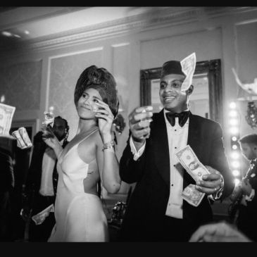 Couple joyfully throwing money in a lively celebration.