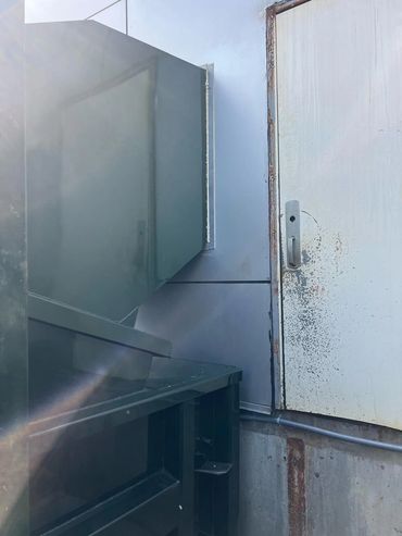 Trash chute hopper at exterior wall above compactor, Elite Containers build-out