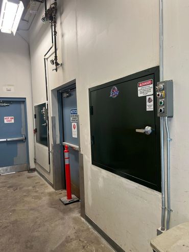 Chute door and control station in building service hallway, Elite Containers build-out