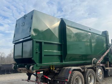 Green self-contained compactor loaded on a roll-off truck, Elite Containers, Waterbury CT