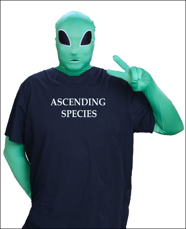 Green alien Dnar wearing the black Dnar shirt backwards holding up 2 fingered peace sign