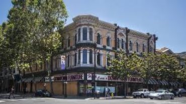 Historic urban building with ornate architecture on a sunny street corner.