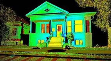 A house illuminated with green and yellow lights at night.