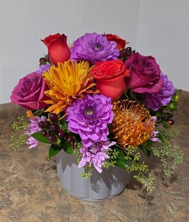 Roses, protea and hypericum berry flower arrangement