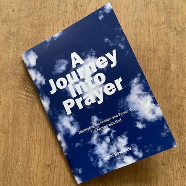 Book titled 'A Journey Into Prayer' on a wooden surface.