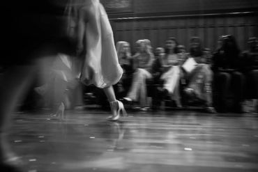 Cheshire Fashion Week Blurred legs of models walking on runway with seated audience.