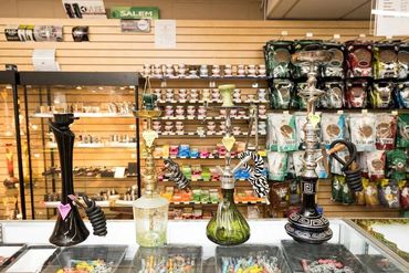 rows of wooden shelves stocked with various brands and sizes of boxed cigars