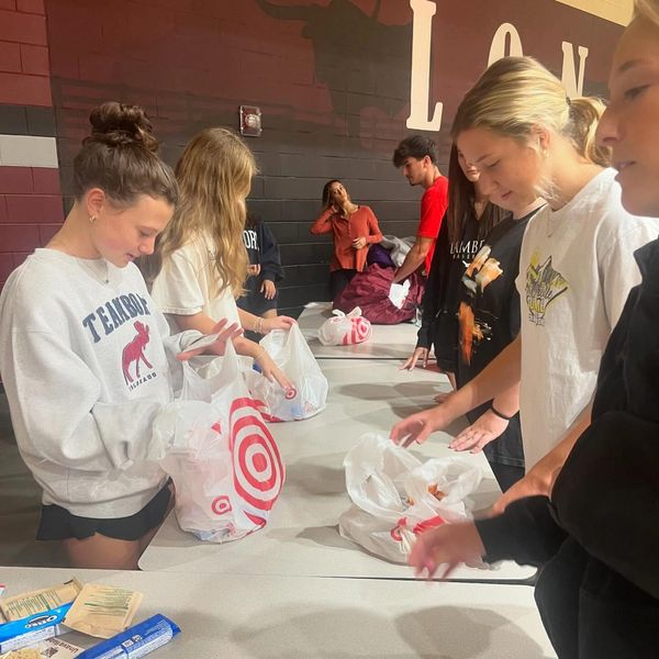 Group packing items into Target bags at a table.