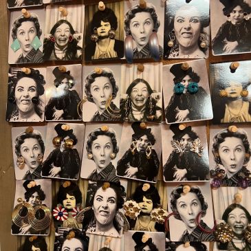 Wall of vintage photo pins on wooden display.