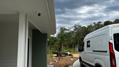 Outdoor security camera installation with weatherproof housing, providing clear night vision and con
