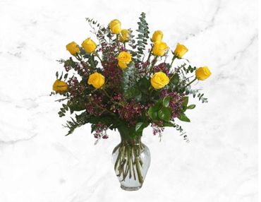 A vibrant bouquet of yellow roses and purple flowers in a clear vase.