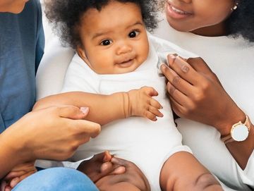 doula and parent holding baby during postpartum visit