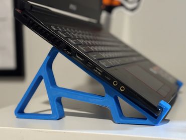 Modern laptop stand supports laptop at high angle, saves space, and stays usable – 2024.