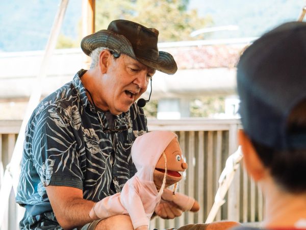 Man with puppet entertaining children.