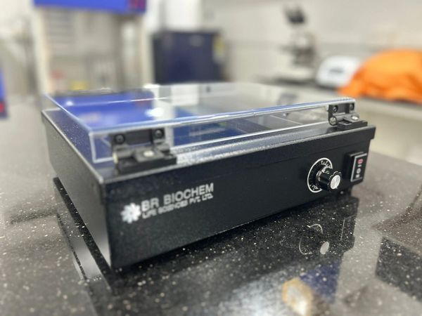 BR Biochem lab equipment with a transparent lid on a black surface.