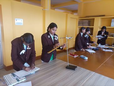 Students in uniforms conducting a science experiment in a classroom.