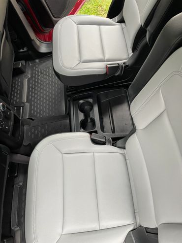 Clean car interior with light gray seats and black floor mats.