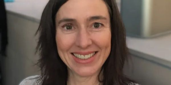 Smiling woman with dark hair.