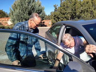 Man transferring from car to wheelchair.